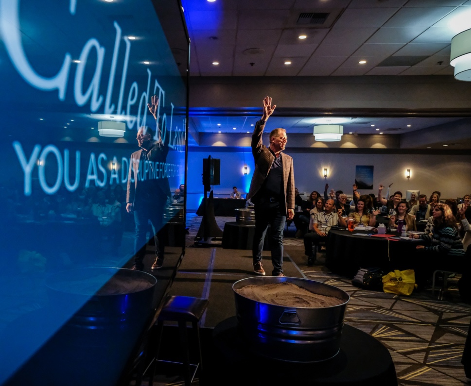 Jeffrey Van Dyk speaking on stage to an engaged audience
