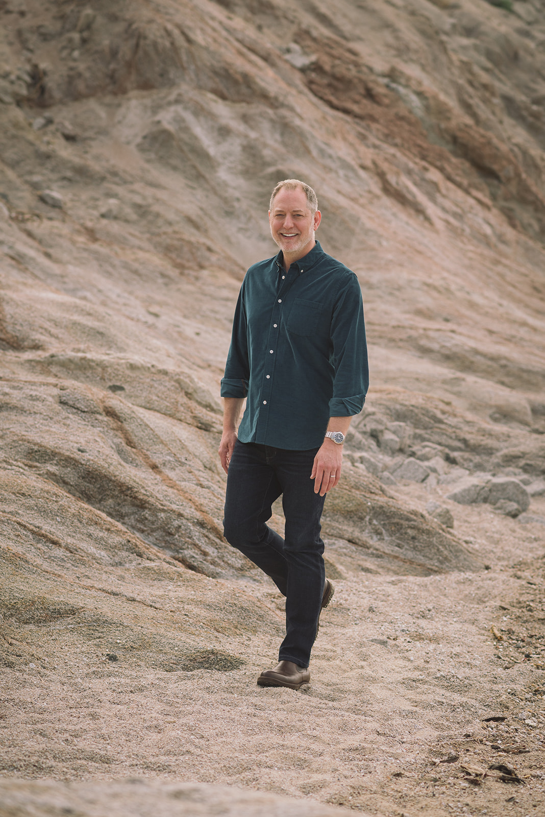 Jeffrey Van Dyk walking across a sandy ridge